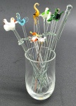 Copo com 14 diferentes espetos decorados com coloridos pássaros e animais, e 02 garfos; itens para aperitivos e com tamanhos variados. Em vidro. Medidas: 15 x 6 cm.