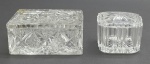 02 diferentes potiches em cristal translúcido, um quadrado e um retangular, com diferentes padrões decorativos. Medidas: 12 x 5 cm; 7 x 5 cm. Tampa do potiche retangular com sinais de restauro.