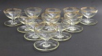 11 taças clássicas de sobremesa, com bojo raso sobre haste curta e base circular ampla para apoio de talheres (pires integrado); em cristal incolor adornado com filetes dourados. Medidas: 9,5 cm x 8 cm. Algumas taças com a douração ligeiramente desvanecida.