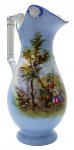 Belíssima jarra azul celeste, adornada na galeria central com colorida cena com músicos em trajes de época em ambiente campestre; em porcelana, numerada no fundo. Medidas: 38 x 20 cm.