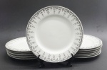 JINGDEZHEN, MADE IN CHINA - Parte de serviço de jantar em porcelana com 12 pratos de sobremesa, decorados na borda com arabescos e motivos florais na cor preta e filetes prateados. Fabricação chinesa, na cidade de Jingdezhen, mundialmente famosa por sua produção de porcelana. Medidas: 20,5 cm (diâm).