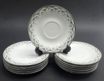 JINGDEZHEN, MADE IN CHINA - 12 pires para xícaras de chá em porcelana, decorados na borda com arabescos e motivos florais na cor preta e filetes prateados. Fabricação chinesa, na cidade de Jingdezhen, mundialmente famosa por sua produção de porcelana. Medidas: 15 cm (diâm.).