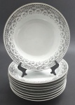 JINGDEZHEN, MADE IN CHINA - Parte de serviço de jantar em porcelana com 09 pratos fundos e 09 colheres de sopa de estilo oriental, decorados na borda com arabescos, motivos florais e geométricos na cor preta e filetes prateados. Fabricação chinesa, na cidade de Jingdezhen, mundialmente famosa por sua produção de porcelana. Medidas: 20 cm (diâm.); 12 x 4 cm.
