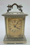 ANSONIA - Antigo relógio mecânico de mesa (carriage clock), a uma corda e com despertador, início séc. XX,  fabricado pela renomada marca americana Ansonia; em caixa de metal prateado decorada com volutas e padrões vegetalistas em relevo; com alça superior adornada com volutas vazadas e elementos geométricos; mostrador em algarismos romanos (horas) e indo-arábicos (despertador); acesso ao mecanismo e à corda pela portinhola traseira. Sineta do despertador e badalos posicionados na parte inferior. Chave inclusa. Medidas: 20 x 12 x 9 cm.  Não testado. Com desgastes no metal e no papel do mostrador compatíveis com a antiguidade da peça.