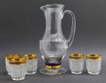 01 jarra e 05 copos em cristal, com diferentes padrões decorativos; jarra com base decorada com anéis na cor azul cobalto e dourada; e copos com corpo lapidado no padrão diamante e borda dourada. Medidas: 27 x 15 cm; 7 x 6 cm.