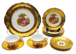 DP 541 - Parte de serviço de chá composto por 01 prato para bolo, 06 pratos de sobremesa, 04 xícaras de chá e 05 pires para xícaras de chá; em porcelana com douração e coloridas cenas galantes nas galerias centrais. Medidas: 28 cm (diâm.); 12 x 5 cm. Douração infimamente desvanecida em alguns pontos.