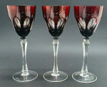03 taças em cristal double na cor rubi, lapidadas com elementos ovais; pé alto com haste multifacetada. Medidas: 23 x 8,5 cm.