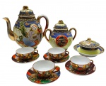 Parte de serviço de café no estilo Satsuma, com diferentes padrões decorativos, sendo: 01 bule, 01 açucareiro e 01 manteigueira em azul e creme, adornados com ideograma japonês; e 04 xícaras de café com seus respectivos pires, em tons terrosos. Todas as peças adornadas com personagens em trajes típicos orientais e detalhes em dourado. Em porcelana casca de ovo policromada. Fabricados no Japão. Medidas: 20 x 19 cm; 8 x 3 cm. Tampa do bule com restauro e danos; uma das xícaras com fio de cabelo; borda do açucareiro com dano; douração desvanecida em alguns locais das peças.