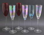 06 taças em cristal de diferentes cores, sendo duas na cor rubi; pé alto, e com diferentes tamanhos e modelos. Medidas: 27 x 8,5 cm; 25,5 x 7,5 cm; 25 x 7 cm.