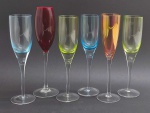 06 taças em cristal de diferentes cores, sendo uma na cor rubi; pé alto, e com diferentes tamanhos e modelos. Medidas: 27 x 8,5 cm; 25,5 x 7,5 cm; 25 x 7 cm.