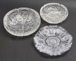 03 cinzeiros circulares em cristal, com diferentes modelos, tamanhos e padrões decorativos. Medidas: 17 x 6 cm; 18 x 5 cm; 15 x 5 cm. Dois cinzeiros com ínfimos bicados na borda.