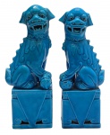 FOO DOGS - Casal de cães-foo, também conhecidos como Leões Guardiões Chineses, cada um sentado sobre base retangular com detalhes triangulares e de volutas vazadas. Tradicionalmente são colocados nas entradas de templos, palácios e residências para afastar os maus espíritos. O macho, com a esfera, simboliza a proteção da estrutura física, e a fêmea, com o filhote, protege as pessoas e a harmonia familiar. Em cerâmica vitrificada na cor azul turquesa. Medidas: 25 x 8 x 6 cm. Ínfimos desgastes na pintura da parte traseira de uma das bases.