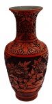 Antigo vaso em laca cinábrio entalhada, e com núcleo metálico em bronze; decorado em relevo com elementos florais e fitomórficos sobre fundo texturizado; base com friso em padrão grega; origem: China. Medidas: 26 x 13 cm.
