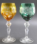 BEYER BLEIKRISTALL, GERMANY - 02 taças em cristal double nas cores âmbar e verde, lapidadas com elementos florais, vegetalistas e ovais; pé alto com haste multifacetada; cristal com 24% de óxido de chumbo, apreciado por sua clareza brilhante. Fabricação alemã. Medidas: 20 x 8 cm.