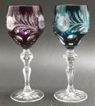 BEYER BLEIKRISTALL, GERMANY - 02 taças em cristal double nas cores vinho e verde, lapidadas com elementos florais, vegetalistas e ovais; pé alto com haste multifacetada; cristal com 24% de óxido de chumbo, apreciado por sua clareza brilhante. Fabricação alemã. Medidas: 20 x 8 cm.