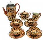 Parte de serviço de café composto por 01 bule, 01 leiteira, 01 açucareiro, 04 xícaras de café e 06 pires para xícaras de café; em porcelana japonesa decorada com coloridos padrões florais e detalhes em dourado; xícaras em porcelana casca de ovo; bico do bule e alças na cor vermelha. Medidas: 20 x 15 cm; 10 x 4 cm. Tampa do bule adaptada; uma das xícaras com ínfimo bicado.