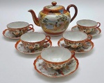 Parte de serviço de chá com 01 bule e 05 xícaras de chá com seus respectivos pires; em porcelana multicolorida adornada com gueixas e detalhes em dourado; xícaras de chá e pires em porcelana casca de ovo; interior das xícaras com relevo floral;  bule com diferente padrão decorativo. Medidas: 21 x 13 cm; 12,5 x 5 cm. Dois pires com bicados sendo um deles também com fios de cabelo; bule com sinais de restauro na alça e manchados no fundo.