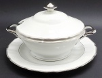 CT TIELSCH ALTWASSER, GERMANY - Parte de serviço de jantar com 01 sopeira circular com seu presentoir, em porcelana alemã; pega da tampa e alças da sopeira, faixas e filetes adornados na cor prata. Marca da manufatura na base. Numerados. Medidas: 30 x 20 cm; 33 cm (diâm).
