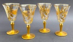 04 taças em cristal no formato trompete, e adornadas com faixas, motivos florais e vegetalistas em dourado; base com douração total. Medidas: 15,5 x 8,5 cm. Alguns pontos com douração ligeiramente desvanecida.