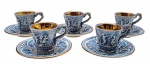 E B R. CAPODIMONTE ITALY - Antigo conjunto com 05 xícaras de café com seus respectivos pires, em cerâmica esmaltada italiana na cor azul; xícaras adornadas em relevo com figuras de putti em ambiente campestre, e com douração total na parte interna; pires decorados em relevo com cesto de frutas, volutas e motivos florais. Marca da manufatura na base das xícaras; xícaras numeradas na base. Medidas: 12,5 x 8 cm. Douração interna das xícaras desvanecida; três xícaras com pequeno bicado na borda.