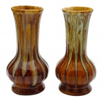 Par de vasos com pescoço cilíndrico e corpo abaulado, em cerâmica esmaltada decorada em tons marrons e bege. Medidas: 21 x 11 cm. Um vaso com ínfimo bicado na borda e o outro com ínfimo bicado na base.
