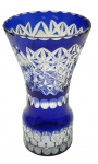 Vaso em cristal double azul cobalto, no formato trompete, lapidado com motivos geométricos e fitomórficos; base cilíndrica. Medidas: 25 x 14 cm. Bicado na borda e trincado no fundo.