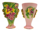Par de belíssimos vasos de corpo cônico e ovalado, pintados à mão com coloridas e exuberantes orquídeas sobre fundo rosa; alças laterais douradas e em espiral; bordas e bases com filetes dourados. Em cerâmica esmaltada; numerados e assinados pela artista (Ada) no fundo. Medidas: 36 x 26 cm. Um dos vasos com ínfimo bicado no fundo.