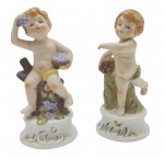 02 bibelôs representando putti, em biscuit policromado. Medidas: 13 x 6 cm.