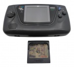 SEGA - GAME GEAR - CONSOLE PORTÁTIL - Antigo console portátil da SEGA lançado em 1990, 8 bits na cor preta, visor iluminado e botões direcionais à esquerda. Direcional em cruz e botões de ação à direita. Acompanha 1 cartucho de jogo do Taz. Funcionamento por pilhas e fonte. Medida: 21cm aproximadamente. Não testado, possui ínfimas marcas e na traseira contém arranhões e marcas de cola.