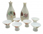 SAKURA, MADE IN JAPAN - SHUKI - Conjunto tradicional japonês conhecido como Shuki, para servir e degustar saquê. Composto por 02 garrafinhas (Tokkuri) e 06 copinhos rasos (Sakasuki); adornados com ideograma, leque e flores de cerejeira. Em porcelana multicolorida. Medidas: 15 x 7 cm; 5 x 3,5 cm. Uma das garrafinhas com tampa ausente.