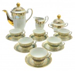 REAL - Parte de serviço de café com 01 bule, 01 leiteira, 01 açucareiro, 06 xícaras de café e 06 pires para xícaras de café; adornados com padrões fitomórficos em dourado, faixas verdes e faixas perolizadas; pegas das tampas e alças em forma de volutas e com douração. Em porcelana. Medidas: 19 x 18 cm; 8,5 x 4 cm.