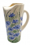 WEISS - Jarra cilíndrica em cerâmica esmaltada decorada com coloridos motivos florais e vegetalistas; bico da jarra com detalhe dobrado. Medidas: 25 x 17 cm. Com ínfimos bicados na borda e na base.