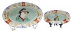 IMARI - 02 travessas ovais em porcelana fina policromada no estilo Imari, Japão, final do séc. XIX / início do séc. XX (Período Meiji/Taisho); borda decorada com delicados ramos florais e reservas em ferro ("iron red" - pigmento vermelho à base de óxido de ferro) e ouro; galerias centrais com a representação de uma figura feminina e uma masculina, em trajes tradicionais japoneses. Reverso da peça com caracteres caligráficos pintados à mão em esmalte vermelho "iron red", indicando o ateliê responsável. Medidas: 33,5 x 22 cm; 23 x 13 cm. Ínfimos pontos de desgaste na pintura compatíveis com a antiguidade das peças; travessa maior com ínfimo bicado no verso; travessa menor com fios de cabelo.