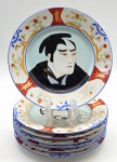 IMARI - 07 pratos rasos em porcelana fina policromada no estilo Imari, Japão, final do séc. XIX / início do séc. XX (Período Meiji/Taisho); borda decorada com delicados ramos florais e reservas em ferro ("iron red" - pigmento vermelho à base de óxido de ferro) e ouro; galerias centrais com a representação de uma figura feminina e uma masculina, em trajes tradicionais japoneses. Reverso da peça com caracteres caligráficos pintados à mão em esmalte vermelho "iron red", indicando o ateliê responsável. Medidas: 23 cm (diâm.). Ínfimos pontos de desgaste na pintura compatíveis com a antiguidade das peças; com ínfimos bicados e fios de cabelo.