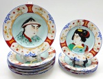 IMARI - 06 pratos fundos e 04 pratos de sobremesa em porcelana fina policromada no estilo Imari, Japão, final do séc. XIX / início do séc. XX (Período Meiji/Taisho); borda decorada com delicados ramos florais e reservas em ferro ("iron red" - pigmento vermelho à base de óxido de ferro) e ouro; galerias centrais com a representação de uma figura feminina e uma masculina, em trajes tradicionais japoneses. Reverso da peça com caracteres caligráficos pintados à mão em esmalte vermelho "iron red", indicando o ateliê responsável. Medidas: 23 cm (diâm.); 20 cm (diâm.). Ínfimos pontos de desgaste na pintura compatíveis com a antiguidade das peças; com ínfimos bicados e fios de cabelo.