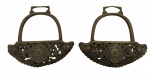 ESTRIBOS - Par de estribos em bronze com detalhes e representações de flores e volutas em relevo e vazados, e com brasão da república ao centro. Medidas: 16 x 17 cm. Possui leves amassados e marcas.