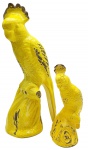 02 esculturas representando aves, de diferentes tamanhos; em cerâmica esmaltada na cor amarela. Medidas: 55 x 23 cm; 30 x 15 cm. Com craquelados superficiais e desgastes no esmaltado; ave menor com bicado e sinais de restauro na crista.