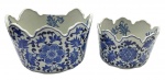02 cachepots ovais de diferentes tamanhos e temática oriental, com bordas onduladas e decorados em azul cobalto no padrão floral tradicional chinês. Em porcelana. Fabricação chinesa. Medidas: 26 x 17 cm; 20 x 14 cm. Cachepot maior com dano na borda.