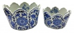 02 cachepots ovais de diferentes tamanhos e temática oriental, com bordas onduladas e decorados em azul cobalto no padrão floral tradicional chinês. Em porcelana. Fabricação chinesa. Medidas: 26 x 17 cm; 20 x 14 cm.