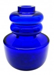 Vaso de estilo modernista e geométrico, trabalhado com dois anéis bulbosos no topo e corpo cilíndrico. Em espesso vidro azul cobalto. Medidas: 23 x 15 cm.