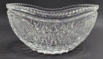Centro de mesa oval com borda serrilhada e adornado em relevo com padrões fitomórficos e geométricos; em cristal translúcido. Medidas: 27 x 13 cm.