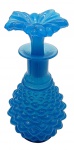 OPALINA - Antigo perfumeiro em opalina azul, apresentando tampa moldada em forma de flor e corpo adornado com elementos ovais em relevo. Medidas: 15 x 7 cm. Ínfimo bicado na parte inferior da flor (tampa).