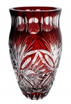 Vaso em espesso cristal double na cor rubi lapidado com padrões fitomórficos, caneluras e elementos geométricos. Medidas: 25 x 13 cm. Ínfimo bicado na borda.