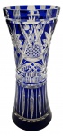 Vaso em cristal double na cor azul cobalto, de formato cilíndrico com parte central ligeiramente estreita, e lapidado com caneluras, padrões fitomórficos e formas elípticas. Medidas: 27 x 11 cm. Ínfimos bicados na base.