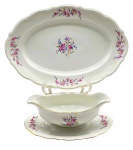 C.T. TIELSCH WABRZYCH, MADE IN POLAND - Parte de serviço de jantar com 01 travessa oval e 01 molheira com presentoir integrado, adornadas com coloridos buquês florais e filete dourados. Em porcelana polonesa. Medidas: 38 x 26 cm; 25 x 9 cm.