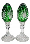Par de ovos decorativos em cristal double na cor verde esmeralda, lapidados com elementos ovais e padrões fitomórficos; apoiados sobre bases pedestais de estilo clássico e com detalhes facetados em cristal incolor. Medidas: 22 x 8 cm.