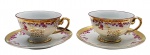 REAL - Par de xícaras de chá com seus respectivos pires, em porcelana adornada com motivos florais na cor rosa e faixas e folhagens em dourado; com a gravação "Bodas de Ouro" em dourado, nas xícaras e nos pires. Medidas: 14 x 7 cm.