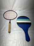 Raquete de badminton vintage da marca Sportcraft na cor vinho com cordas coloridas, cabo de madeira sem grip protetor e capa de proteção acolchoada na cor azul. Medindo a maior 24cm x 45,5cm.