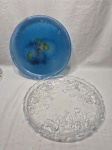 Lote de 2 pratos de bolo em vidro. sendo um azul e um moldado. Medindo o maior 36cm x 4cm de altura.