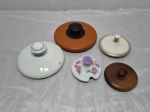 Lote de 5 tampas em porcelana, madeira e metal. Medindo o maior 14cm de diâmetro.